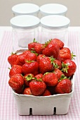 Fresh strawberries in cardboard punnet; jam jars