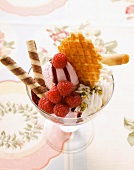 Sundae with raspberry ice cream, cream and wafers