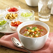 Gazpacho in soup bowl, surrounded by ingredients