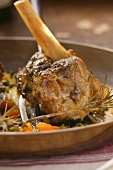 Braised lamb shank with vegetables and rosemary in pan
