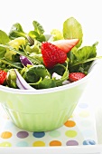 Spring salad with red onions and strawberries in bowl