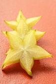 Three slices of carambola on red background