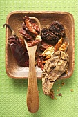 Various dried chili peppers in wooden bowl