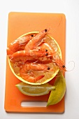 Shrimps in bowl with ice cubes; lemon wedges