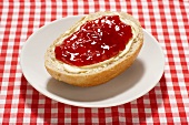 Bread roll with butter and strawberry jam