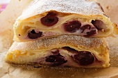 Two pieces of cherry strudel with icing sugar