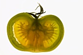 Half a green tomato, backlit