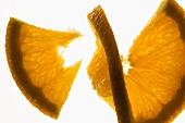 Slice of orange cut into two pieces, backlit