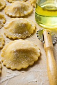 Home-made ravioli with pastry wheel and olive oil