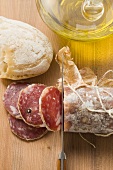 Italian salami with slices cut, white bread, olive oil