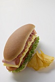 Ham, cheese, tomato and lettuce sandwich with crisps
