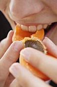 Woman biting into apricot