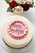 Birthday cake with the words 'Happy Birthday', roses