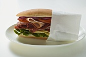 Salami, ham and cheese sandwich in napkin
