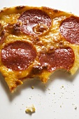 Stück Pizza mit Salami und Käse, angebissen