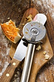Piece of pizza, pizza cutter and server