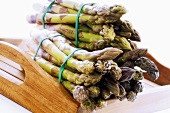 Bundles of green asparagus on wooden table