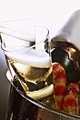 Two champagne glasses & bottle & shrimps in champagne bucket
