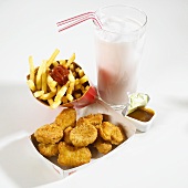 Chicken nuggets, chips, sauce and milkshake