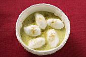 Poached meringues with pistachio sauce