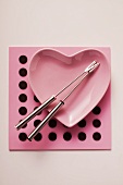 Pink heart-shaped plate with two fondue forks
