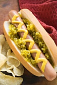 Hot dog with relish, mustard and crisps
