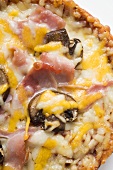 Mini-pizza with ham, mushrooms and cheese