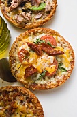 Three different mini-pizzas and bottle of olive oil