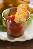 Fischstäbchen mit Ketchup (angebissen)