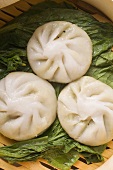 Three filled yeast dumplings on pak choi (Thailand)