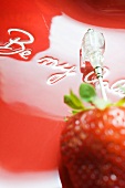 Strawberry on cocktail stick on red plate for Valentine's Day