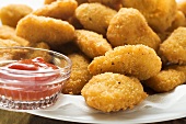 Many chicken nuggets with ketchup on plate