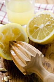 Lemons with wooden squeezer and lemon juice