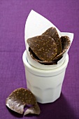 Chocolate curves with chopped nuts in beaker