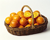 Fresh oranges in a shallow wicker basket