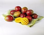 Mangos on green kitchen cloth, one cut into cubes