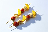 Two sweet strawberry and orange kebabs with marshmallows