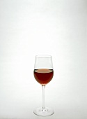 A filled tall red wine glass
