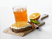 Orange jelly on bread and in jar