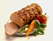 Roast pork roll with vegetables, a slice carved