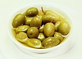 Eingelegte, grüne Oliven in einem weissen Schälchen