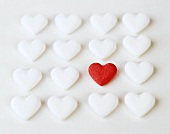 Grape sugar hearts, several white and one red