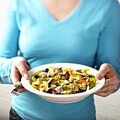 Woman holding a salad with barbecued vegetables