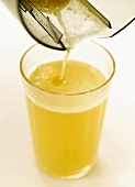 Freshly pressed apple juice running into a glass