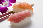Nigiri-Sushi mit Thunfisch und Lachs, Essstäbchen & Orchidee