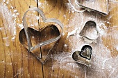 Heart-shaped biscuit cutters on floured board