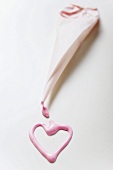 Pink heart in glacé icing and a piping bag