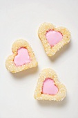Three heart-shaped biscuits with pink icing