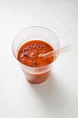 A glass of pepper and vegetable smoothie with straw