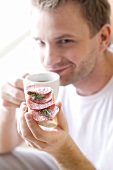 Young man with open salami sandwich and a cup of coffee